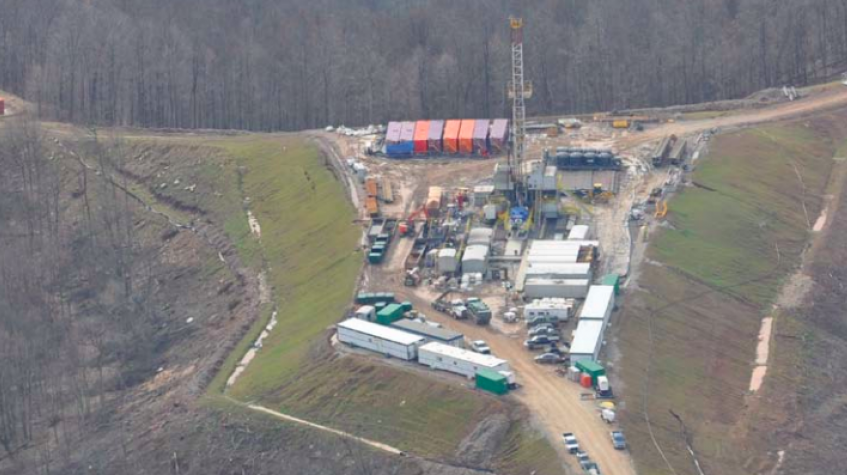 A fracking site with equipment, machinery, storage containers and structures.