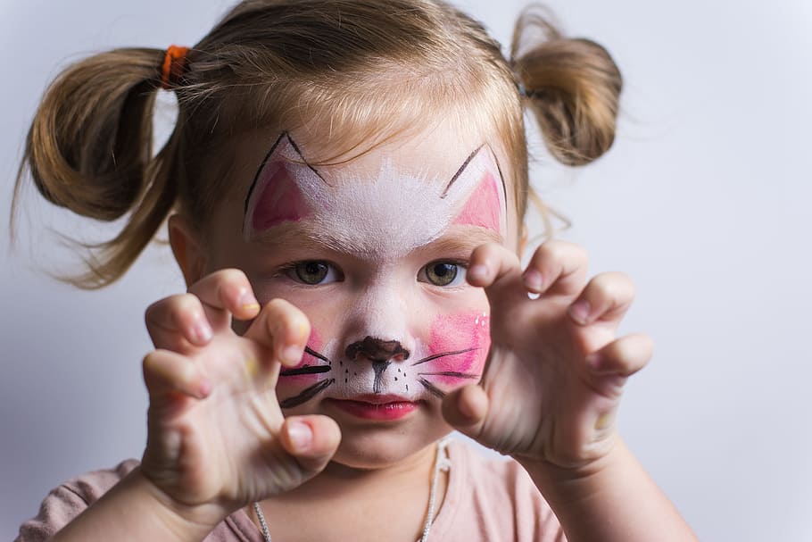 Child wearing Halloween makeup for a cat costume