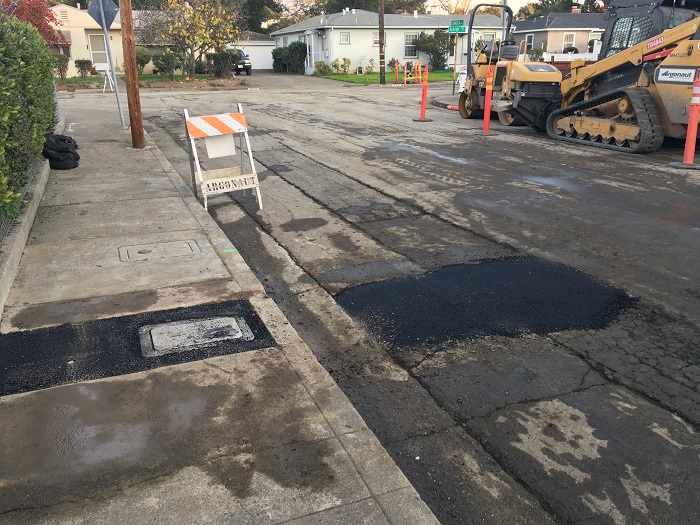 temporary asphalt patches on street and sidewalk
