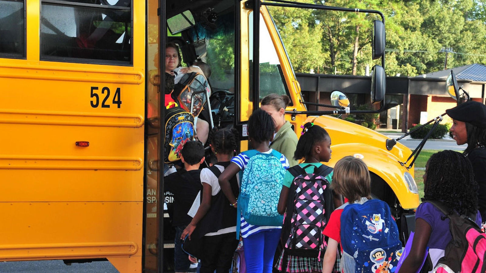 Children getting on a yellow school bus