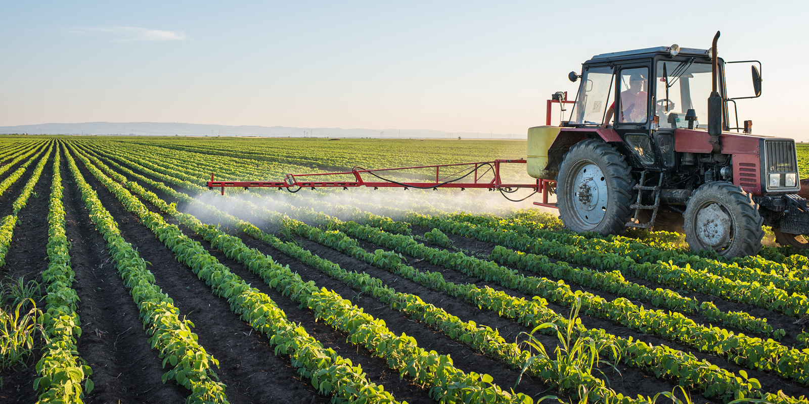 Tractor spraying herbicides on field