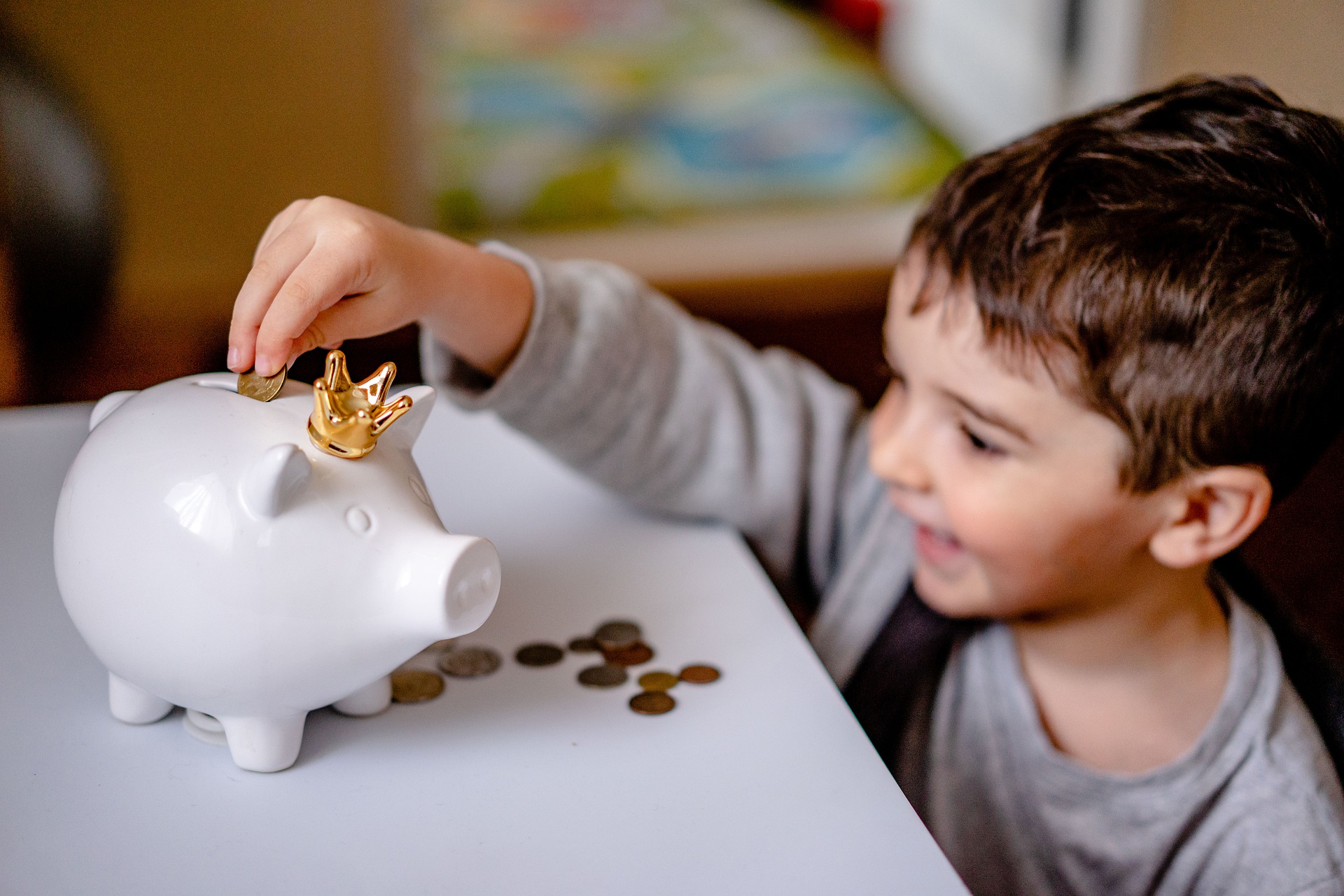 child putting coin into white piggy bank