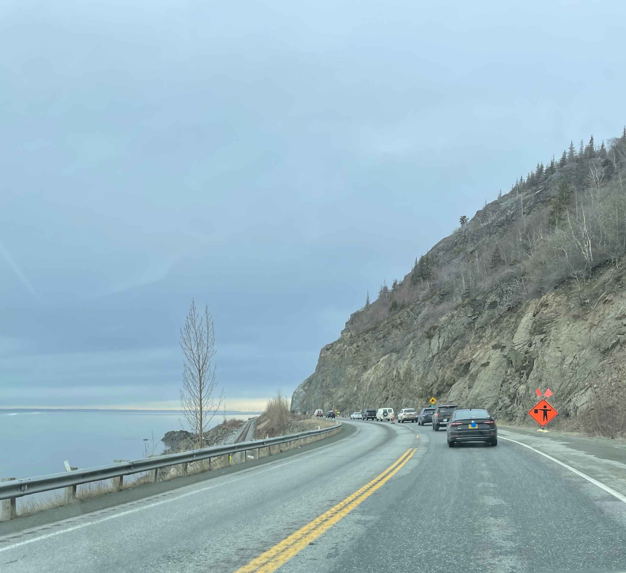 photo of cars lined up for construction on Seward Highway, train tracks visible.