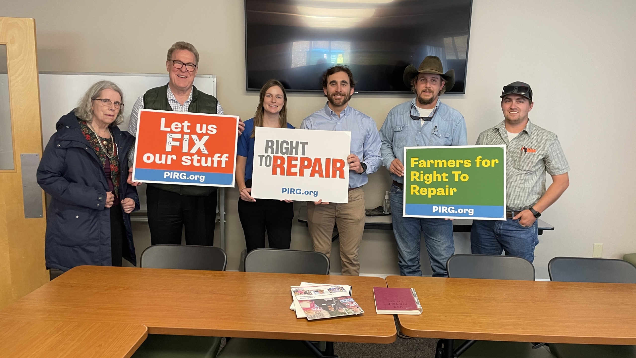 Six right to repair advocates holding signs that say 