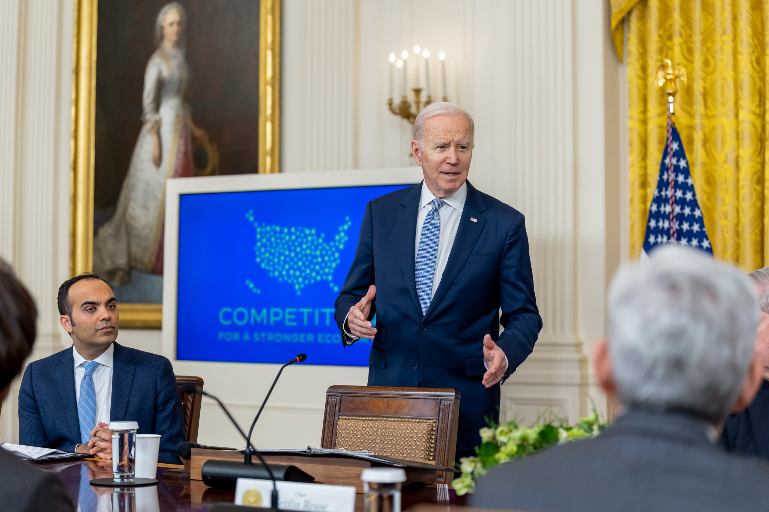 President Biden speaks to the White House Competition Council on February 1, 2023. At left is CFPB director and former FTC commissioner Rohit Chopra.