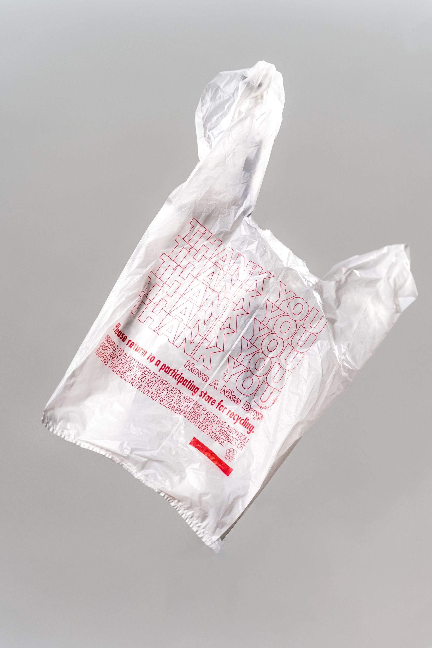 A plastic bag floats in front of a gray background