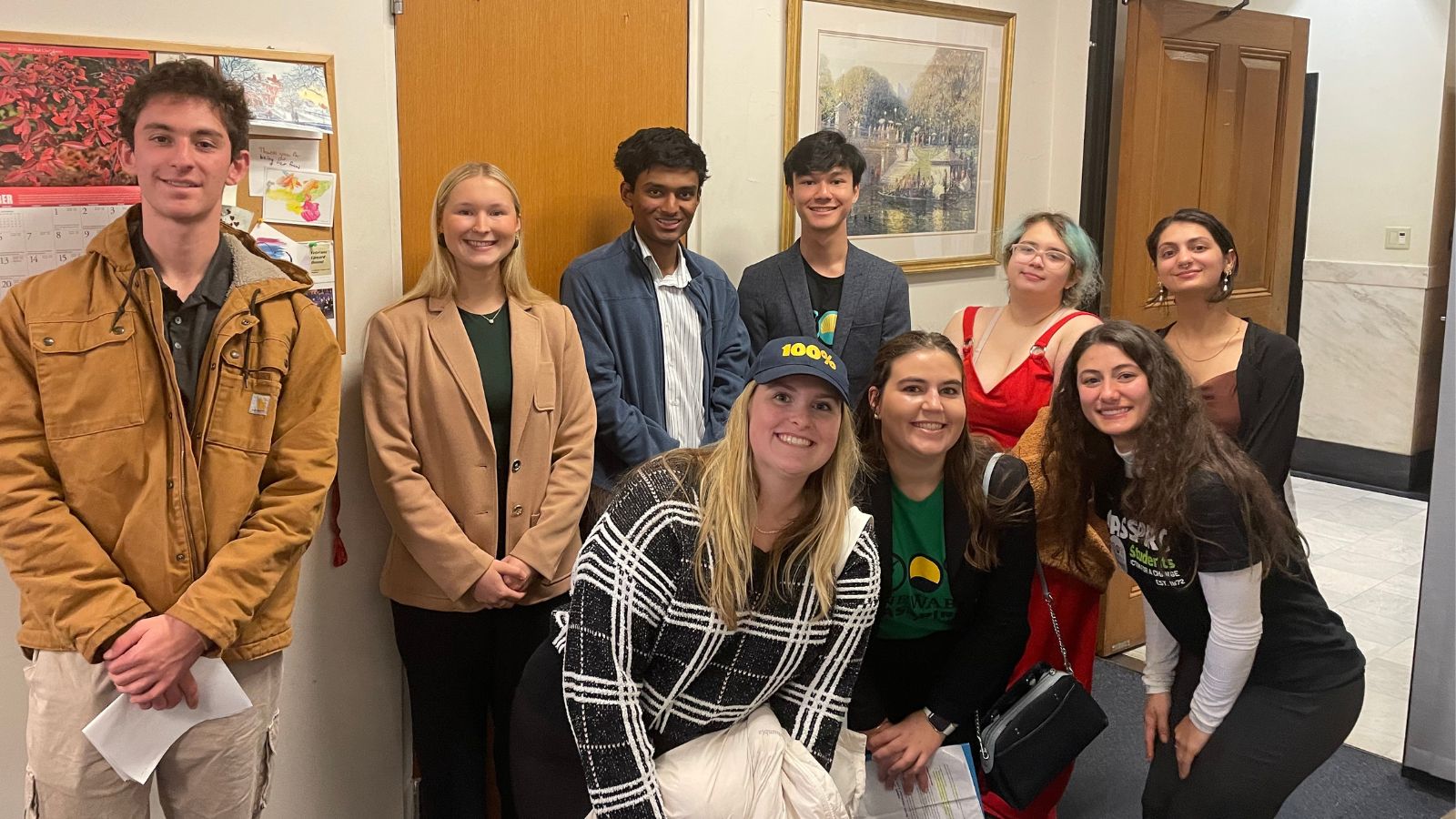 8 students meet with a legislator's staff person at the Massachusetts State House.