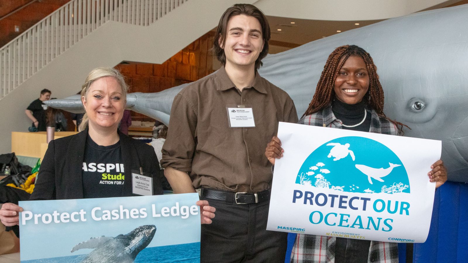 Two students and Leigh Anne Cole hold Protect our Oceans sign and Cashes Ledge sign at Youth Oceans Summit.