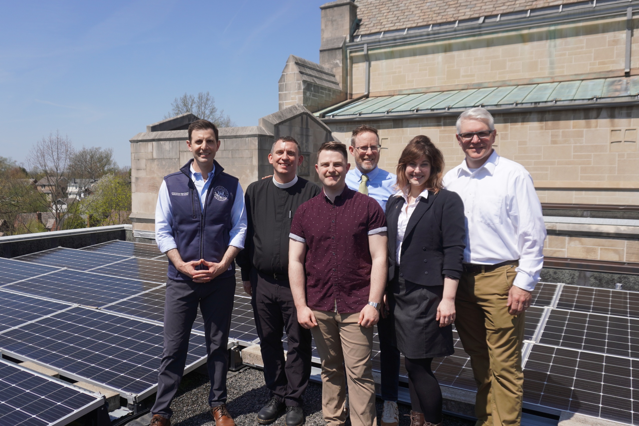 Congressman Deluzio, PennEnvironment, and leaders from St. Pauls gather around solar panels on the roof of a church
