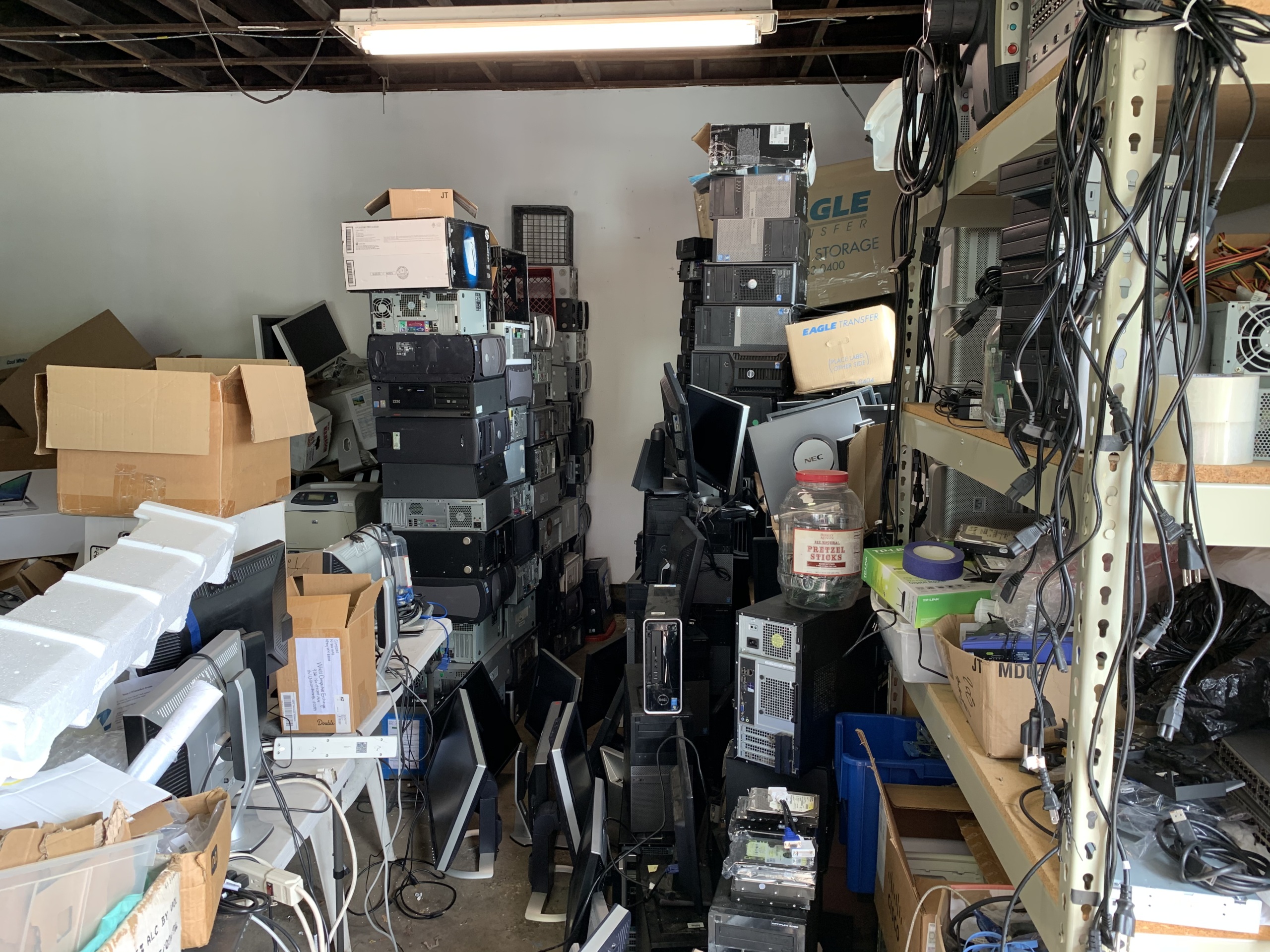 Monitors, desktops, and cables are piled floor to ceiling in a local garage.