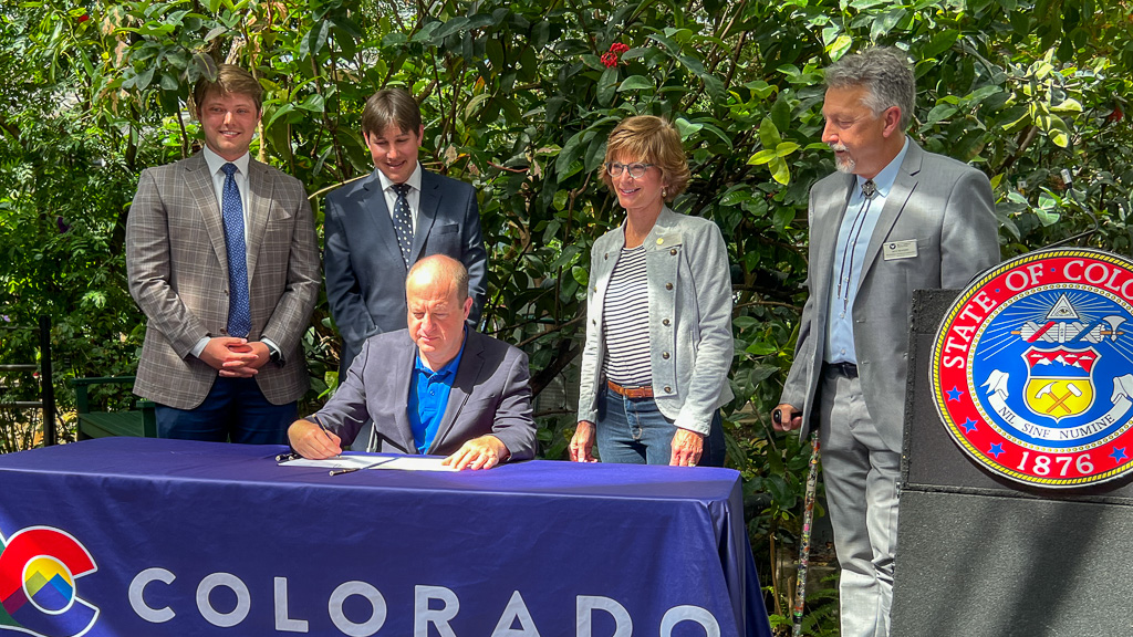 Governor Polis, surrounded by key bill supporters, signing HB24-1117. From left to right: Marcus H. Catlin, First Gentleman Marlon Reis, Representative Karen McCormick (bill sponsor), Colorado Parks and Wildlife Commissioner Rich Reading