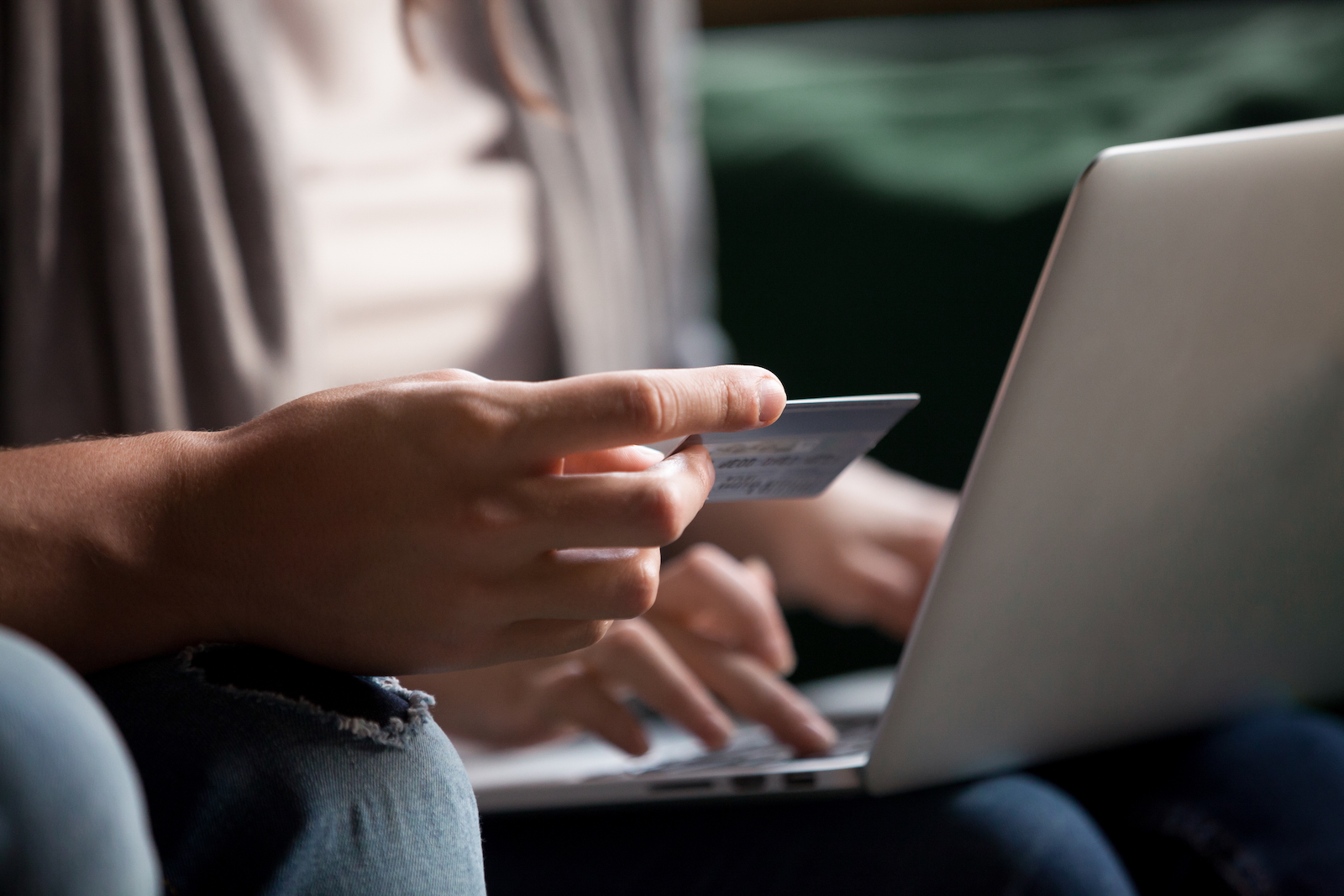 Person paying with credit card on laptop