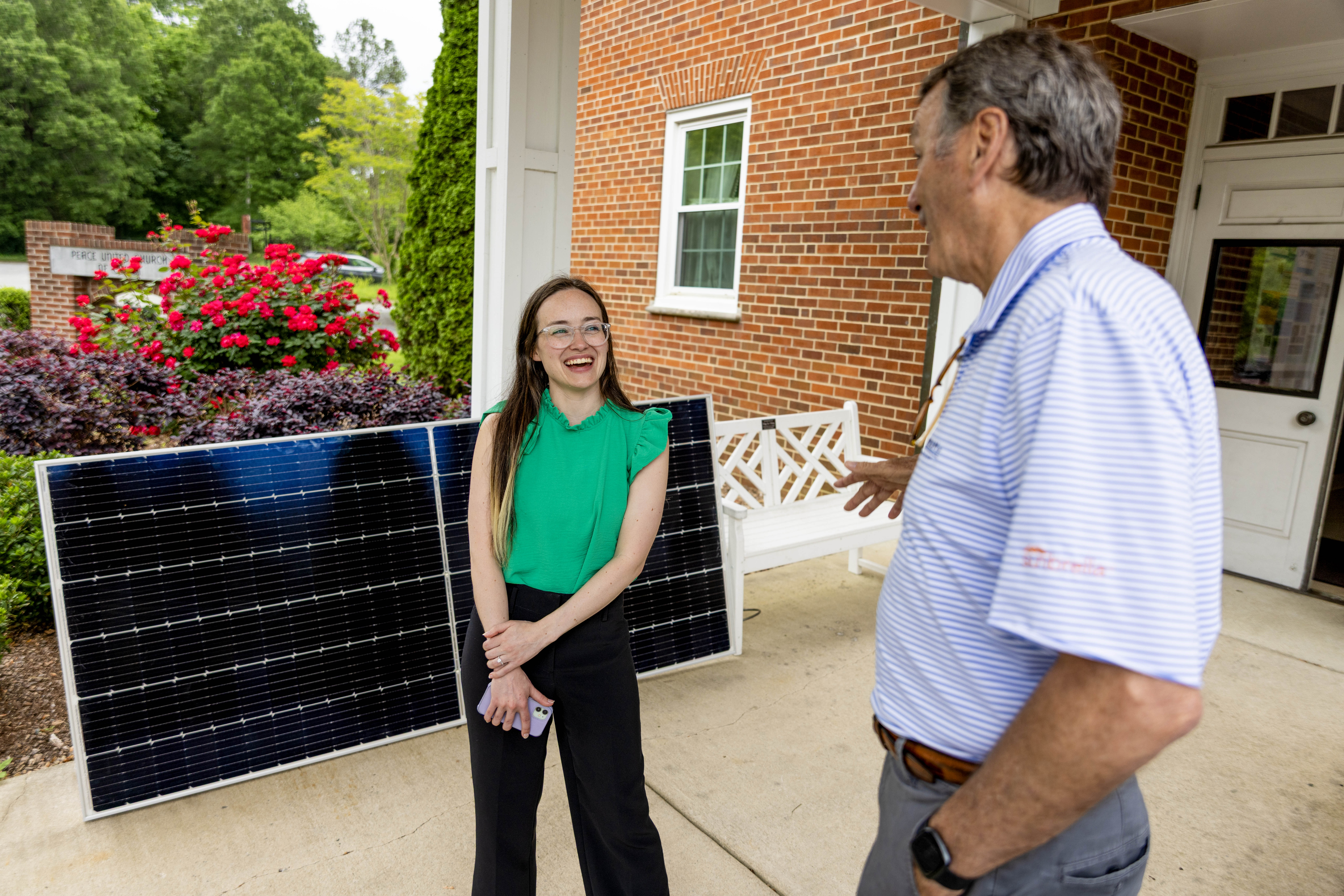 Environment NC Advocate Emily Mason talking in front of solar panel at PUCC solar church tour in Greensboro NC